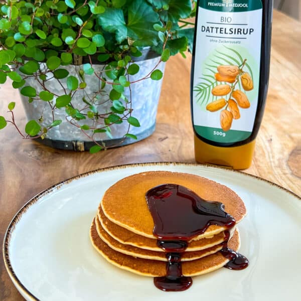 Ist Dattelsirup gesund? Dattelsirup auf Pancakes, eine von vielen Verwendungsmöglichkeiten des natürlichen Süßungsmittels!