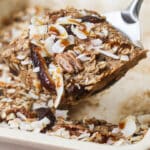 Ein Stück Ginger Baked Oats – Ingwer Haferauflauf mit Medjool Datteln wird aus der Auflaufform genommen