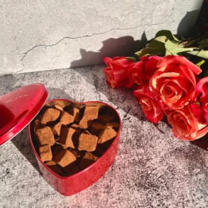 Schokoladen-Dattel-Trüffel ohne Zucker in Herzdose mit Kakaopulver