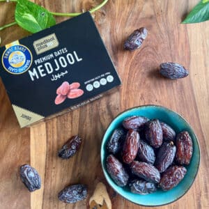 1 kg Premium Medjool Datteln in der Dattelgröße Super Jumbo. Datteln in einer Schüssel serviert neben der 1 kg Packung.